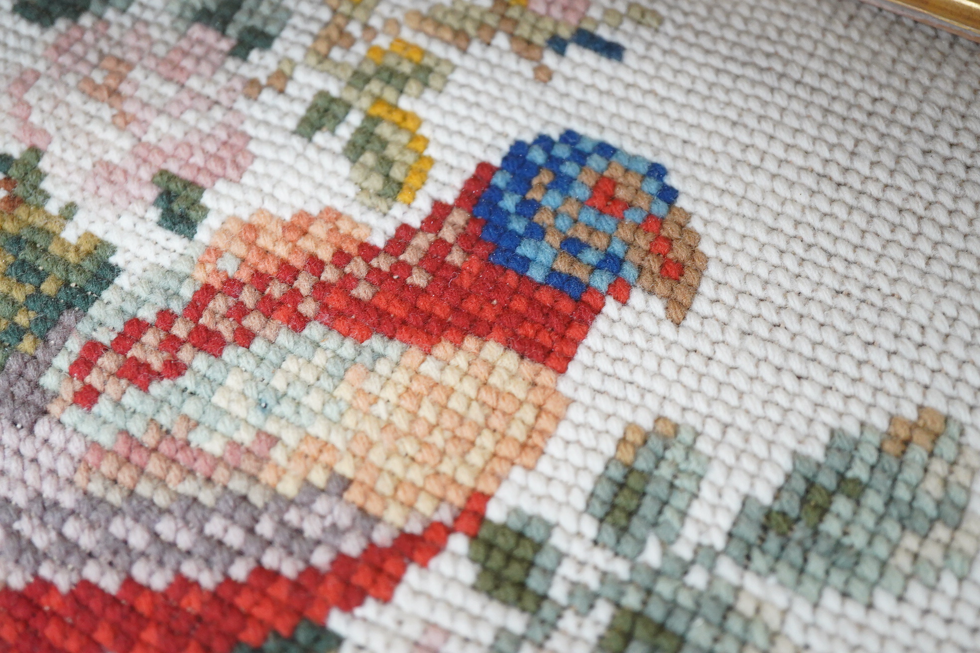 A framed 19th century woolwork embroidery of a bird, a floral wool bell pull with gilt mounts and a large maple frame